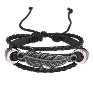 Détail d'un bracelet multicouche en cuir avec pendentif plume argentée et cordons tressés
