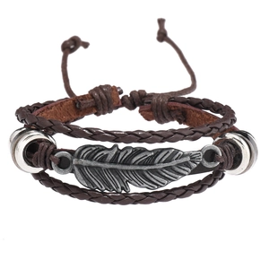 Gros plan d'un bracelet en cuir marron multicouche avec un pendentif plume en métal ciselé