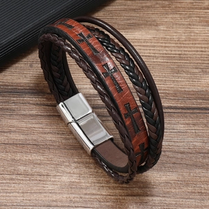 Close-up of men's braided leather bracelet featuring cross embossing and magnetic clasp