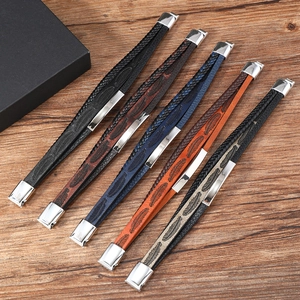 Detail view of leather woven bracelets with feather patterns and steel clasps on wood