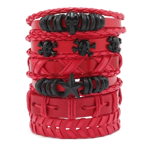 Detail van rode meerlagige gevlochten leren armbanden met zwarte doodshoofdjes