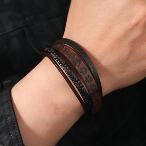 Close-up of men's layered leather bracelet featuring hexagon star embossing and braided straps