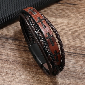 Macro detail of men's leather bracelet with embossed cross pattern and magnetic clasp