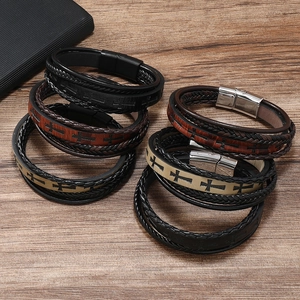 Detail showing various colors of men's leather braided bracelets with cross patterns