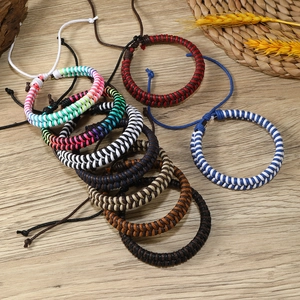Close-up of handmade colorful braided rope bracelets with adjustable knots on wood