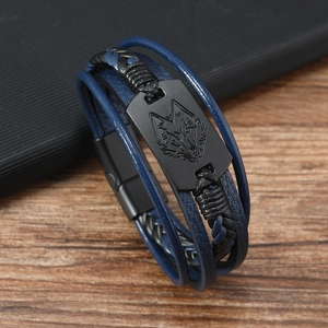 Dettaglio del bracciale multistrato in pelle con testa di lupo incisa su metallo