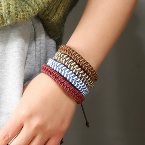 Close-up of four colorful handmade braided cord bracelets on wrist with adjustable straps