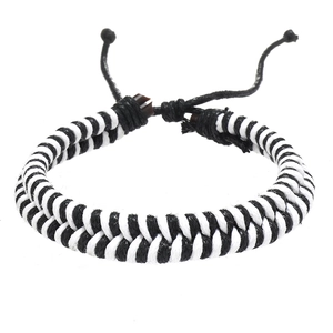 Detailed macro of black and white hand-woven double-strand bracelet with adjustable knot