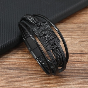 Close-up of multi-layer black leather bracelet with eagle head relief on metal plate