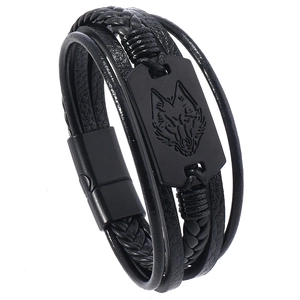 Dettaglio del bracciale multistrato in pelle con placca metallica a testa di lupo e fibbia