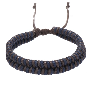 Detail of handmade dual-strand woven bracelet in blue and brown with adjustable slide knot