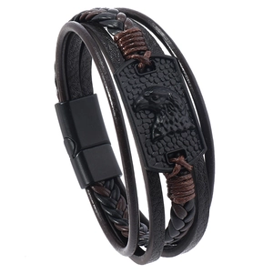 Macro shot of men's leather bracelet showing eagle relief on black alloy plate