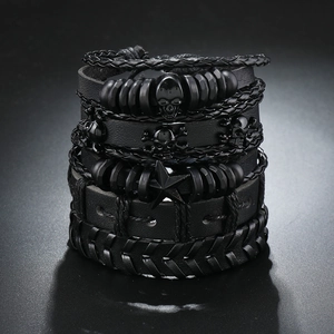 Detail van zwarte lederen gevlochten armbanden met schedelbedels en steraccenten