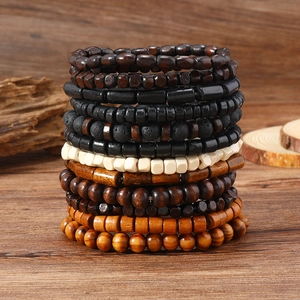 Detail of multi-layered beaded bracelets with wood beads and volcanic stone on wood
