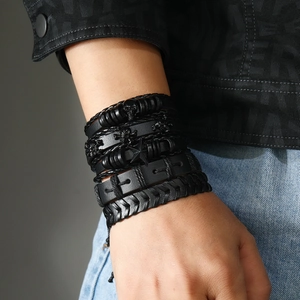 Detailopname van heren lederen armbanden met schedel en ster om de pols gedragen