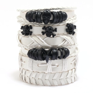 Detailopname van meerlaagse leren armbanden met punk schedels en sterren in wit
