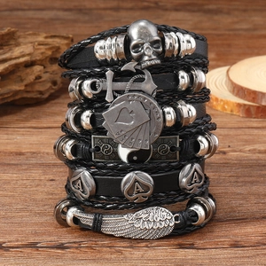 Close-up of punk style multilayer leather bracelets with skull, anchor and wing metal charms