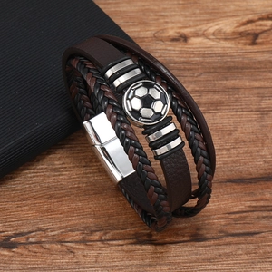 Close-up of multilayer leather bracelet with a soccer pattern metal charm and magnetic clasp