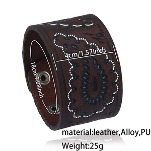 Macro detail of brown leather cuff bracelet with white paisley stitching and alloy snaps