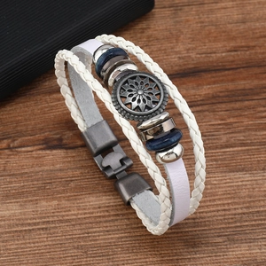 Detailansicht eines mehrlagigen Lederarmbands mit vintage Sonnenblumen-Metallanhänger