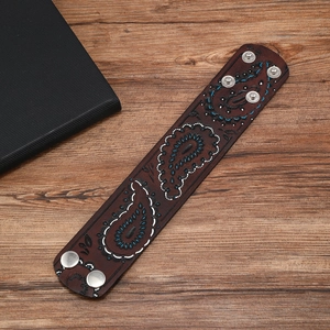 Vintage brown leather cuff bracelet with paisley pattern and silver metal snap buttons