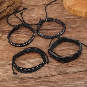 Herren 4er-Set schwarze Lederarmbänder mit Unendlichkeitssymbol auf Holzuntergrund