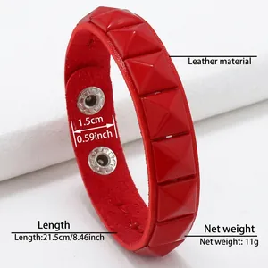 Détail d'un bracelet punk en cuir rouge avec rivets carrés et fermeture à pression