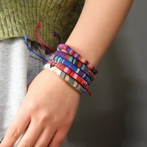 Detail of colorful woven bohemian bracelets on wrist with adjustable braided cords