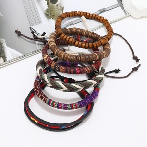 Detail of multi-layer men's leather bracelet set with ethnic beads and woven cords