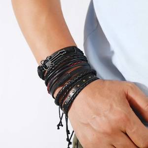 Dettaglio del bracciale multistrato in pelle da uomo con ciondolo chitarra e rivetti