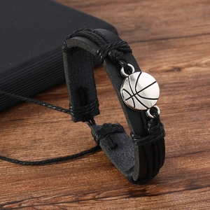 Detail of multi-layer black braided leather bracelet featuring a silver basketball charm