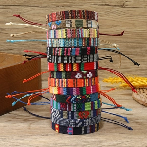 Bohemian woven friendship bracelets in various colorful patterns on wood background