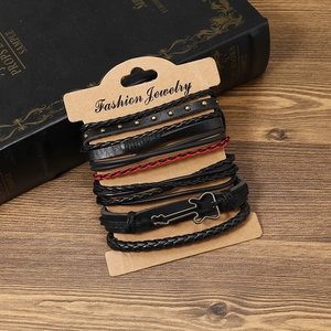Dettaglio del set di braccialetti multistrato in pelle con ciondolo a chitarra in metallo
