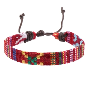 Handmade ethnic woven bracelet with red geometric patterns and adjustable cord