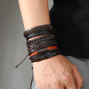 Detail of multilayer braided leather bracelet for men featuring tree of life and orange accent