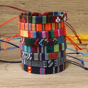 Close-up of stacked colorful bohemian woven bracelets with geometric patterns and texture