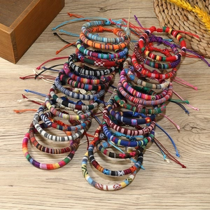 Colorful Bohemian hand-woven friendship bracelets with geometric ethnic patterns on wood