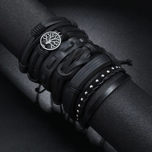 Macro detail of multi-layer black leather bracelets with silver Tree of Life charm