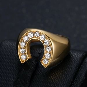 U-shaped gold horseshoe ring for men with inlaid white zircons on a dark background