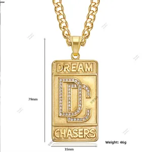Detail of gold-plated DC dog tag pendant showing dimensions 79mm by 35mm and crystal inlay
