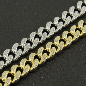 Vue macro de chaînes cubaines glacées serties de zircons en finitions or et argent