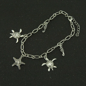 Silver marine bracelet with turtle, seahorse, and starfish charms on a black background