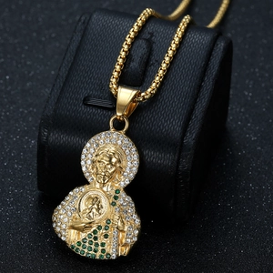 Pendentif Saint Jude doré avec cristaux brillants présenté sur un support en cuir noir élégant