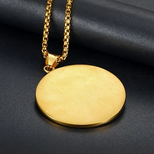 Polished gold round Eye of Providence pendant with a brushed finish on a black texture