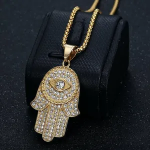 Gold plated Hamsa Hand pendant necklace with full rhinestone pavé on a black display stand