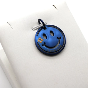 Gros plan du pendentif smiley bleu roi avec gravure Love Life et trèfle orange vif