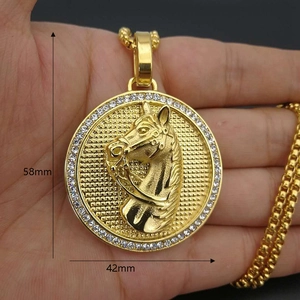 Detail of 18k gold plated horse head medallion pendant with crystal bezel on hand