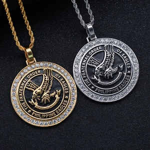 Detailed close-up of gold and silver eagle coin pendants with white zircon stones