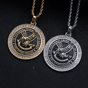 Detail of gold and silver eagle crest pendants with crystals and braided chain
