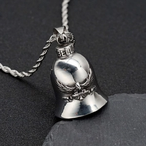 Close-up of vintage stainless steel eagle relief guardian bell pendant with rope chain